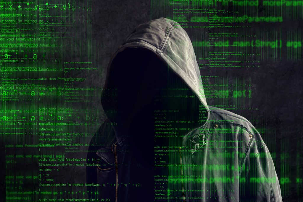 Man in dark hoodie with shadowed face against a green digital background
